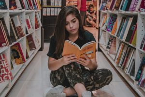 woman-sitting-on-floor-while-reading-2393789